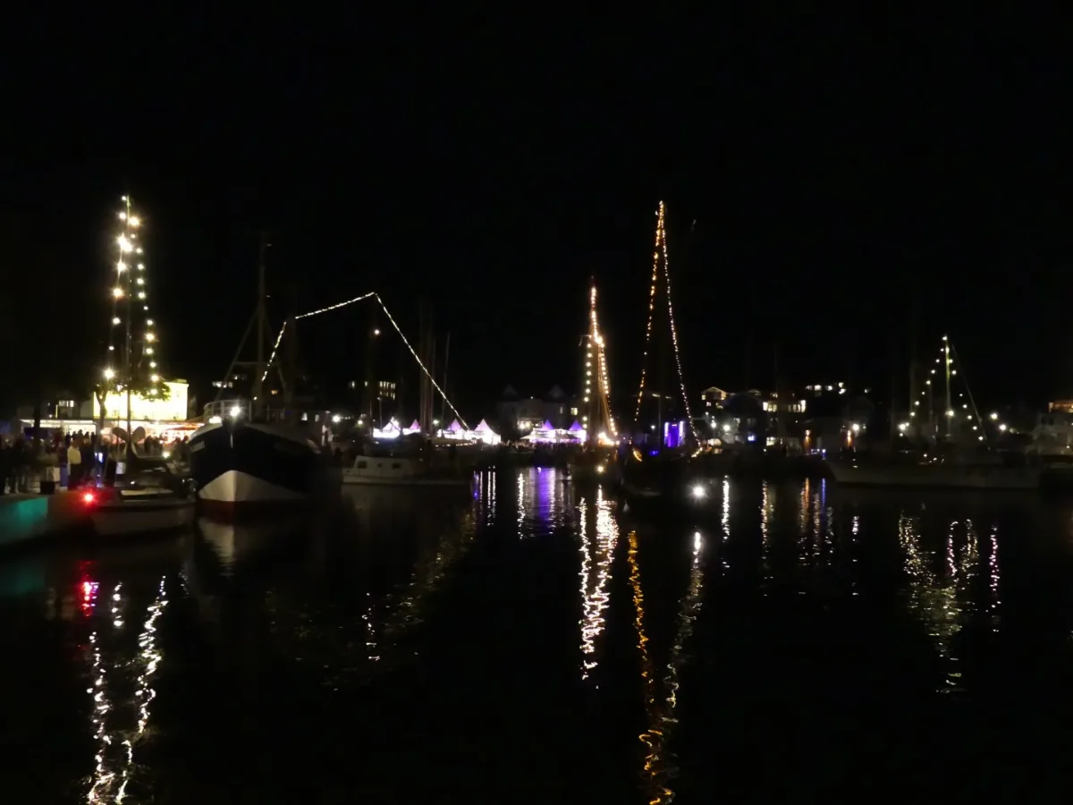 Beleuchtete Schiffe im Hafen bei Nacht